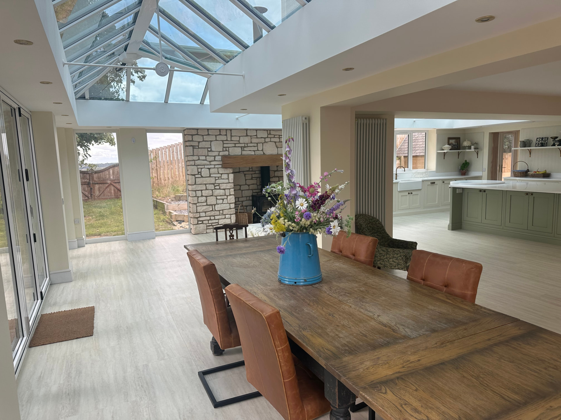 Dining area beneath a glazed lantern roof with bifold doors to the garden