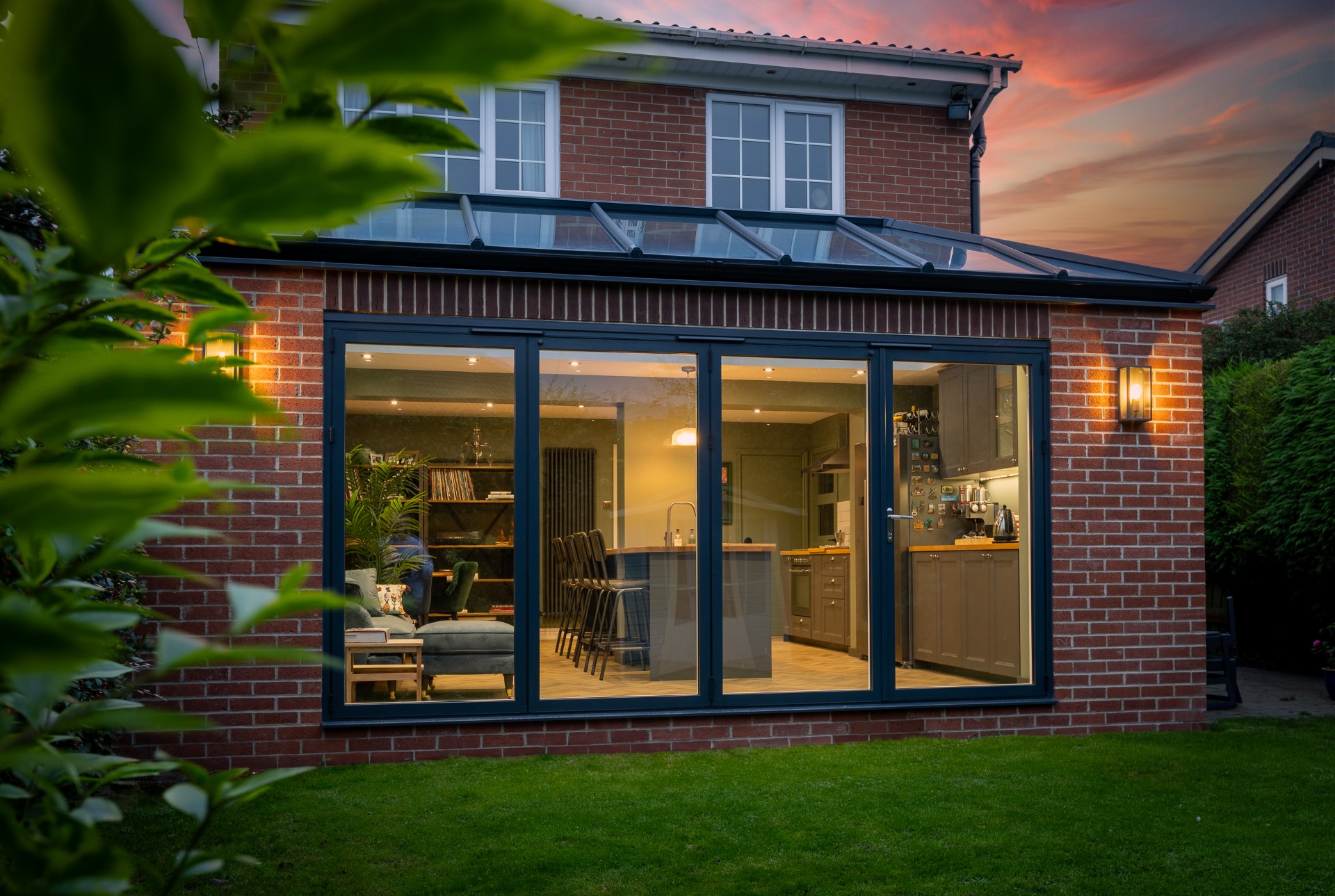 Sunderland extension lit from within at dusk with anthracite bi-fold doors