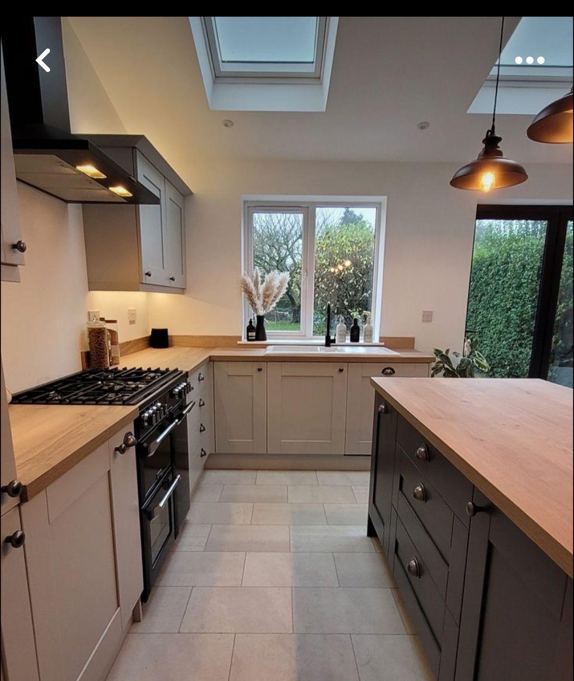 Stone shaker cabinetry with range cooker, oak worktops and garden views