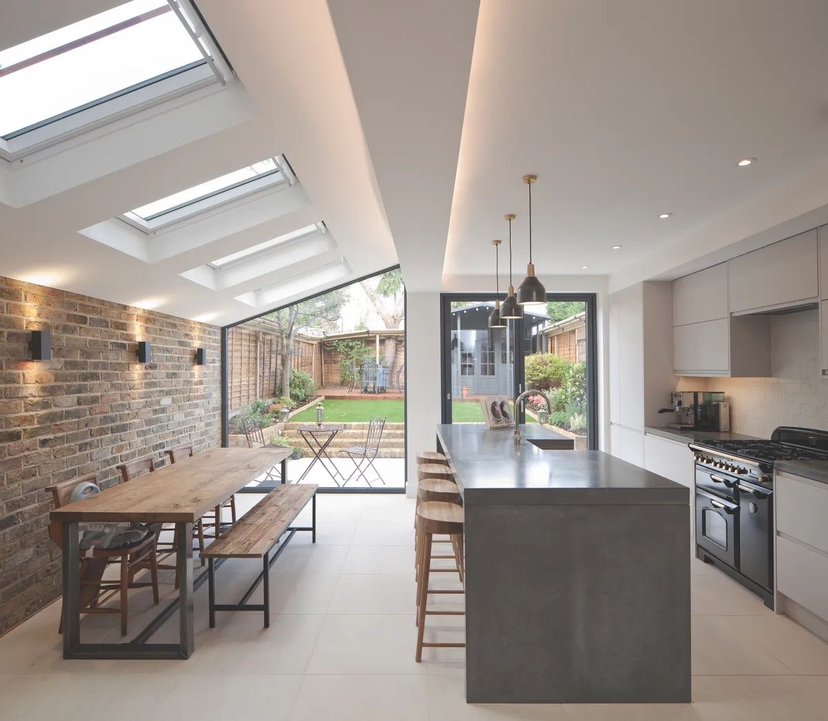 Open-plan kitchen and dining space with roof lanterns and garden views