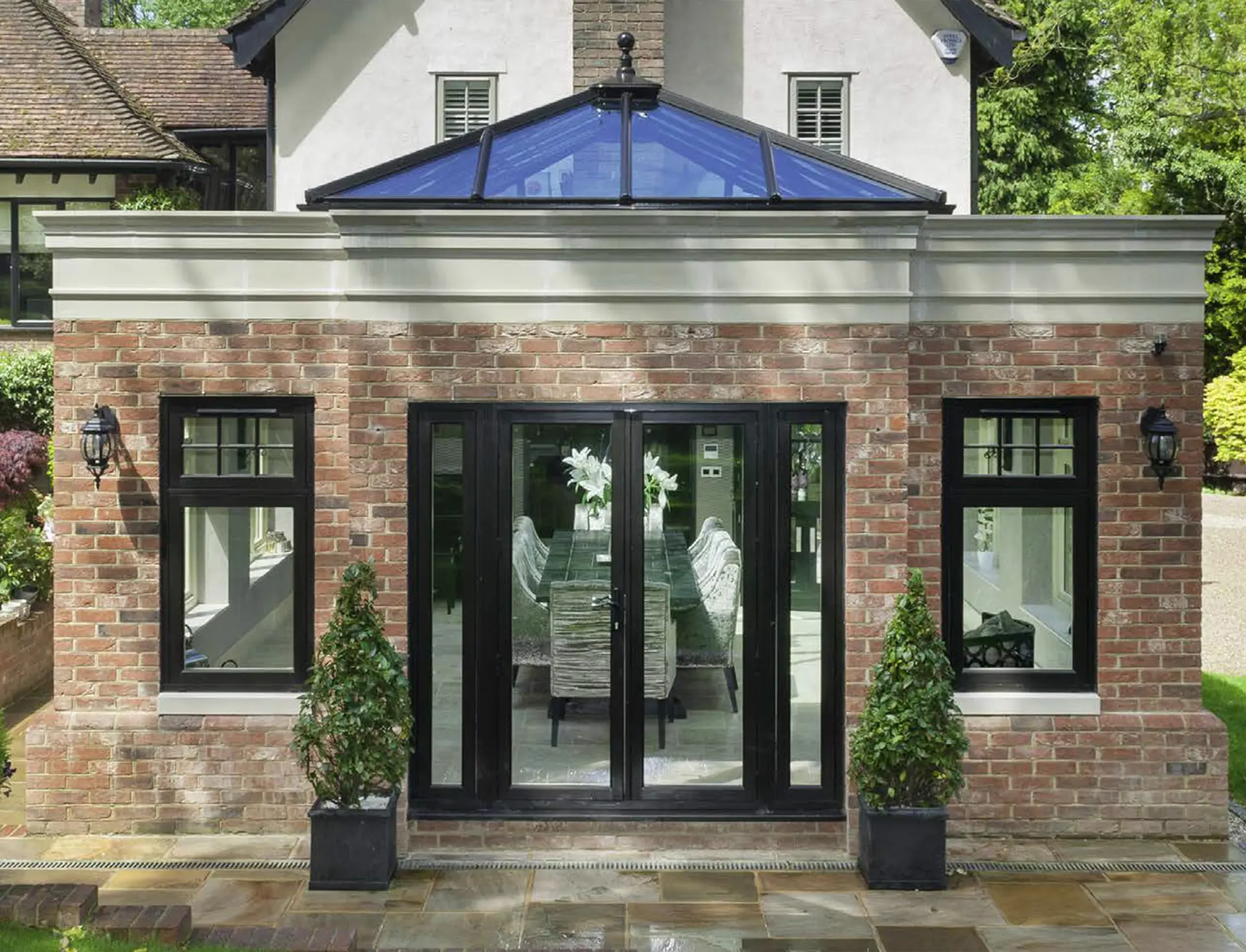 Traditional brick orangery extension in Stanhope with cast-stone parapet and glass roof lantern by Alpine Extensions