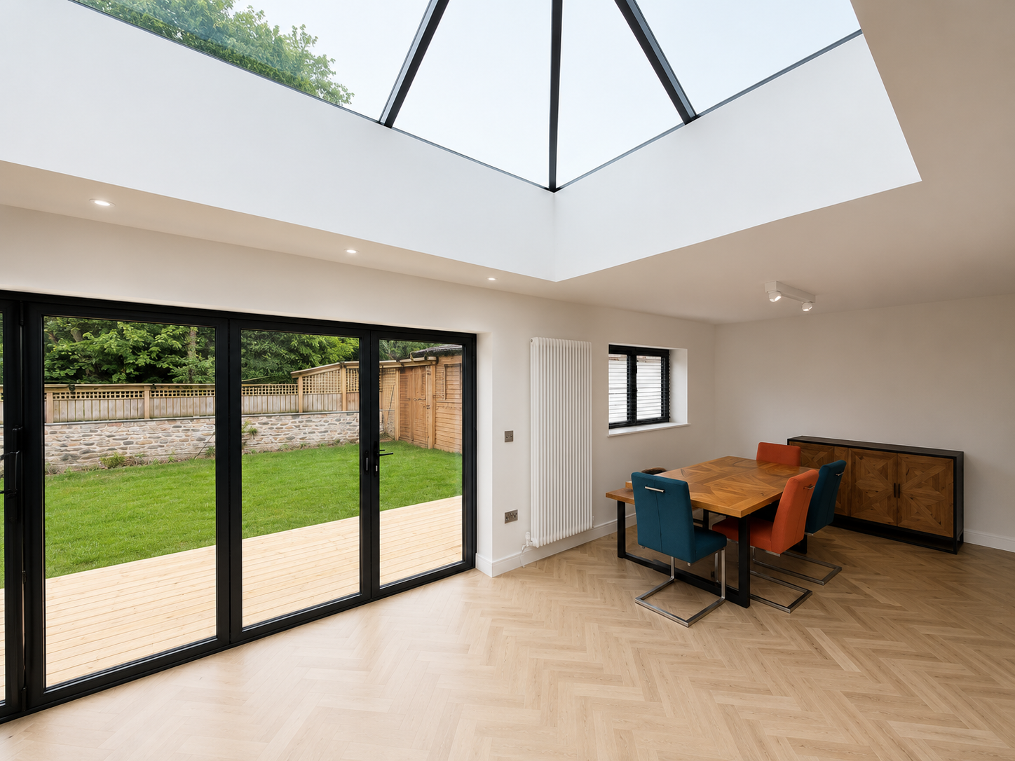 Orangery dining area with bifold doors open to the garden