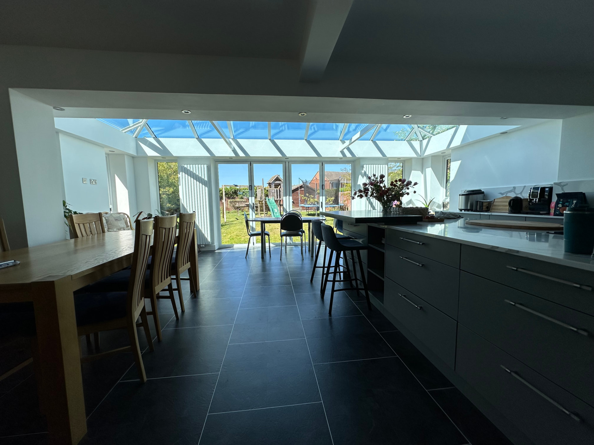 Open-plan kitchen and dining area looking towards the glazed roof and garden