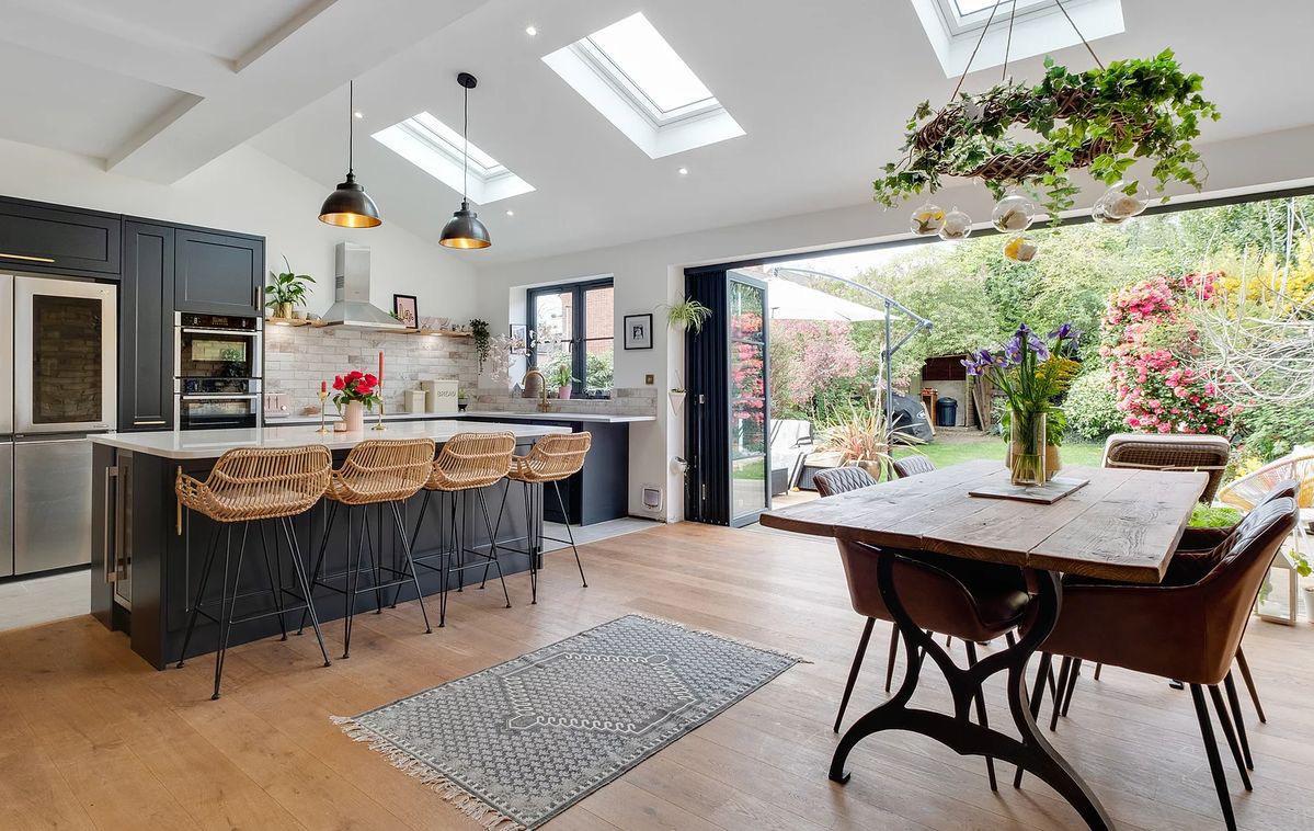 Open-plan kitchen and dining space with bifold doors open onto the garden