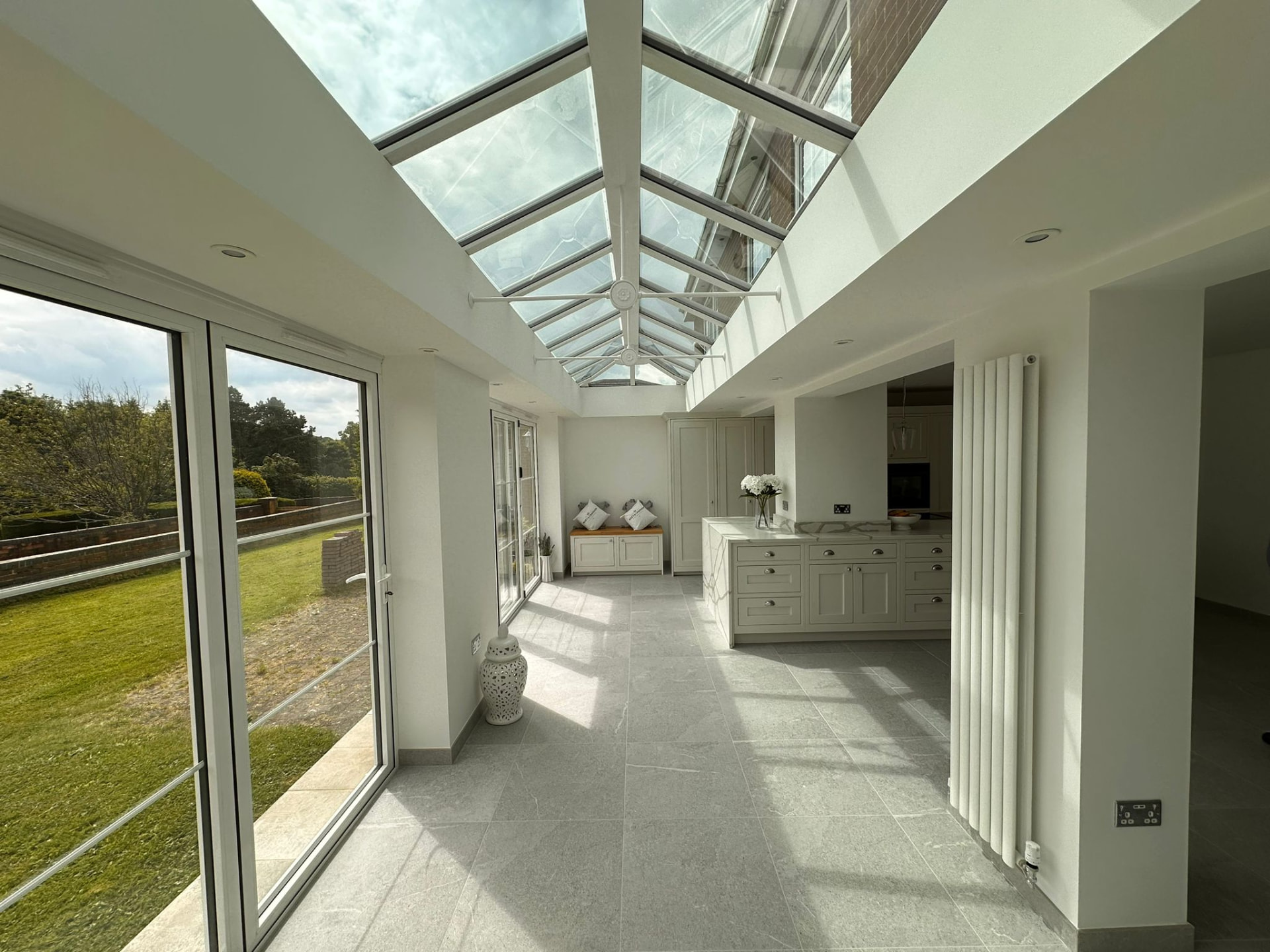 Orangery interior with glazed lantern roof, bifold doors and garden views