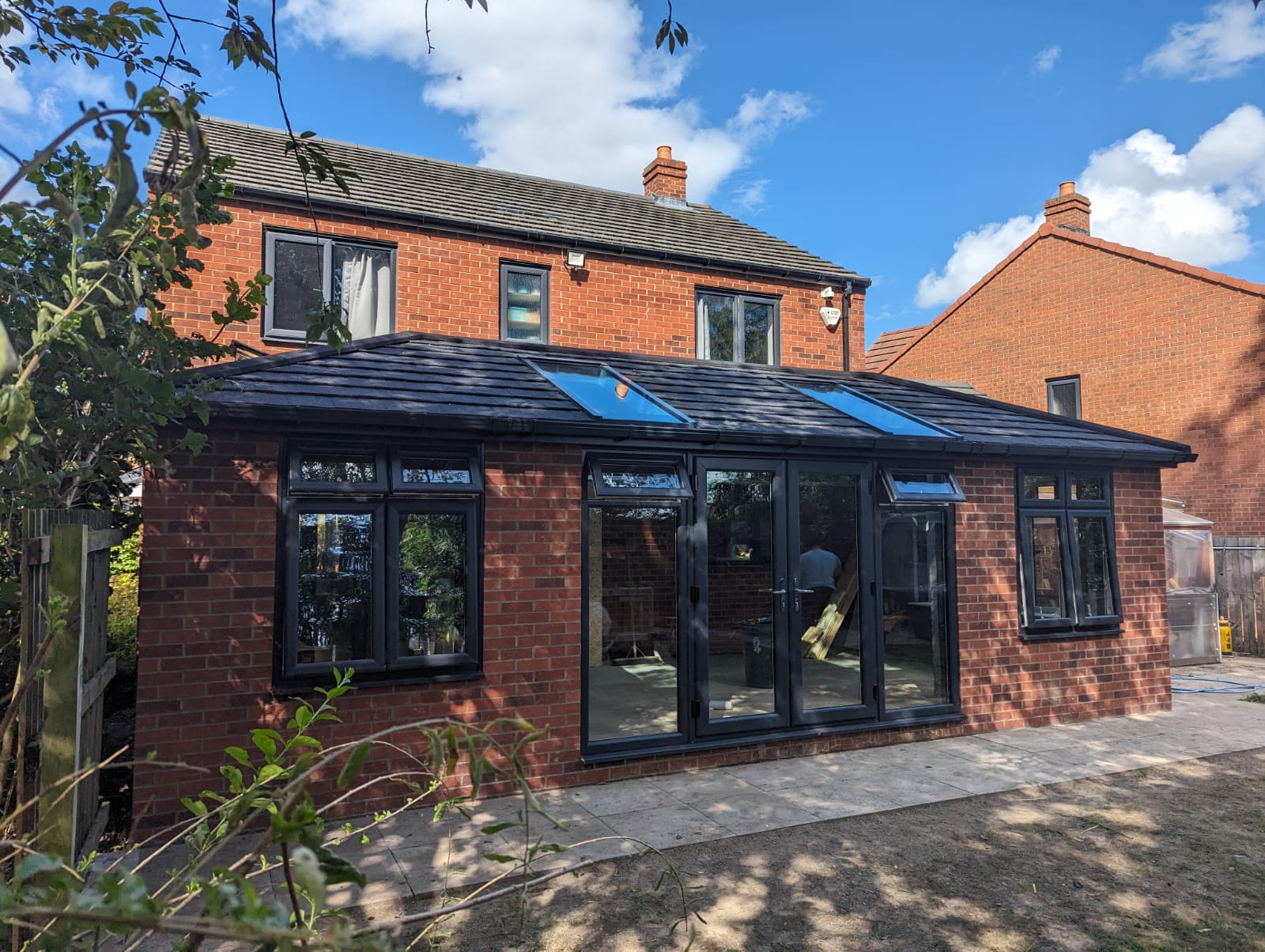 Brick conservatory conversion in Seaburn with a solid tiled roof, glazed roof panels and anthracite grey French doors