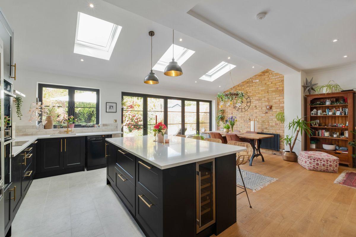 Quartz topped island with exposed brick wall and dining area beyond