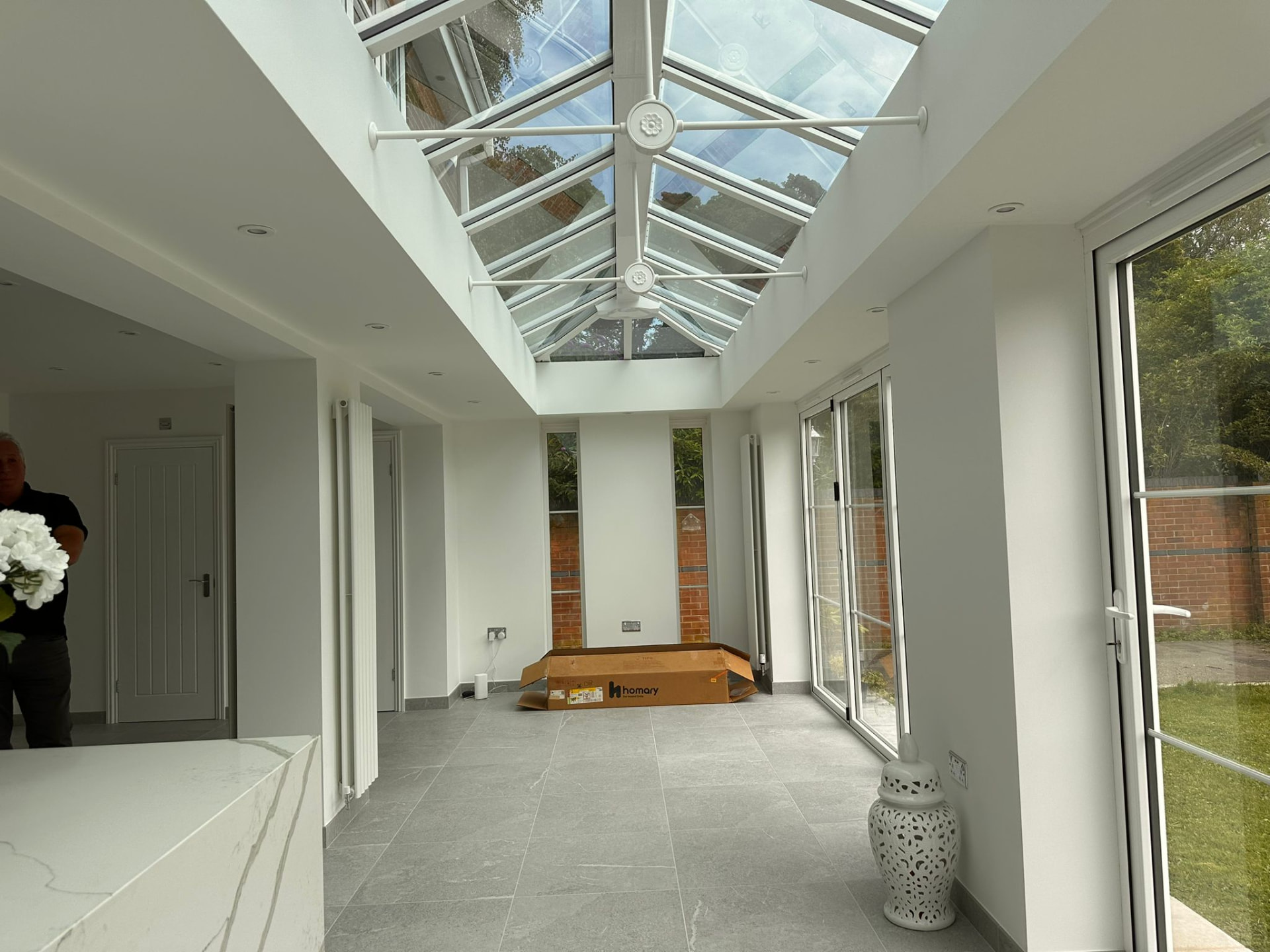 Glazed lantern roof with white frames above stone porcelain flooring
