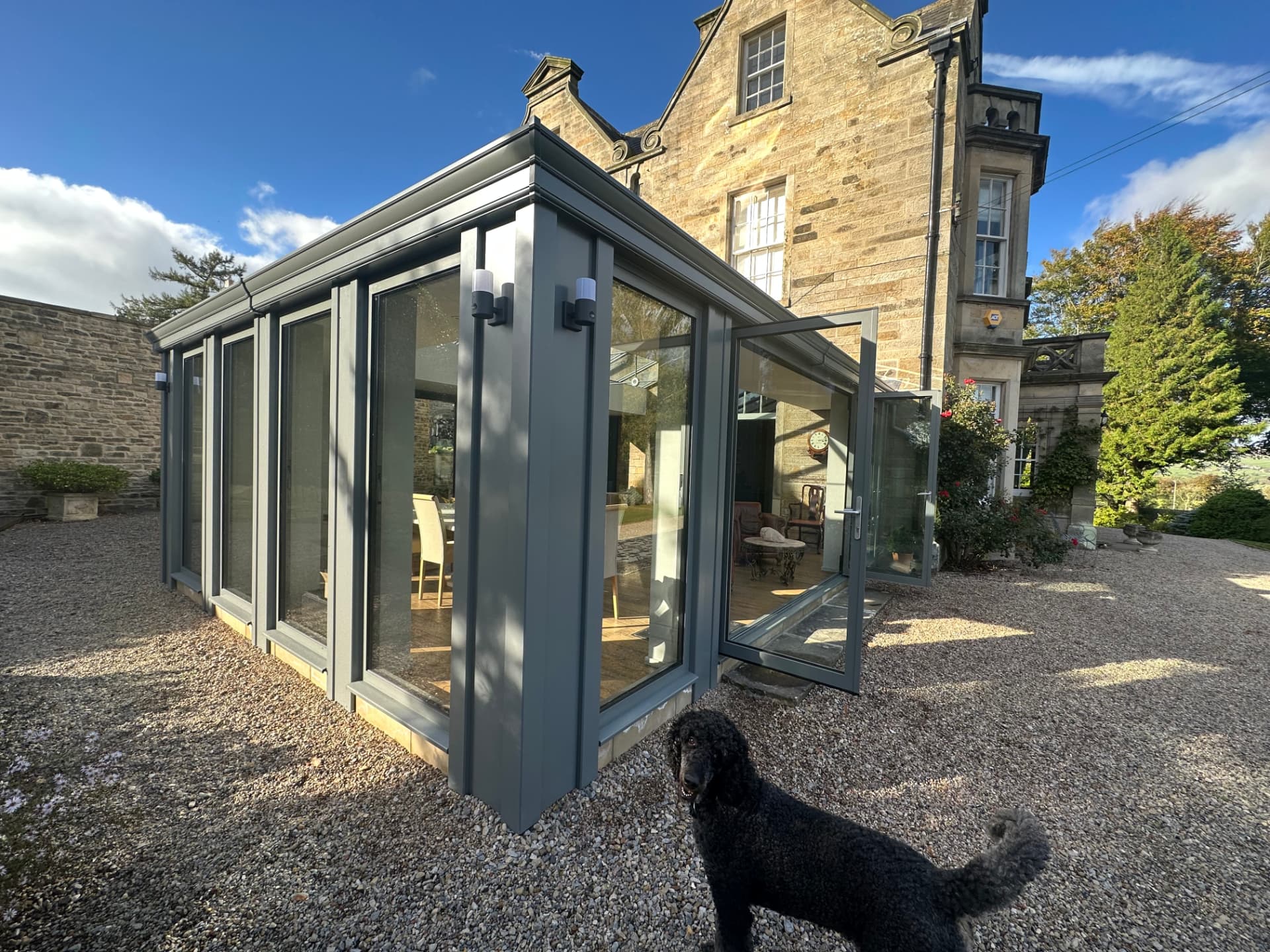 Corner view of the aluminium orangery with open French door
