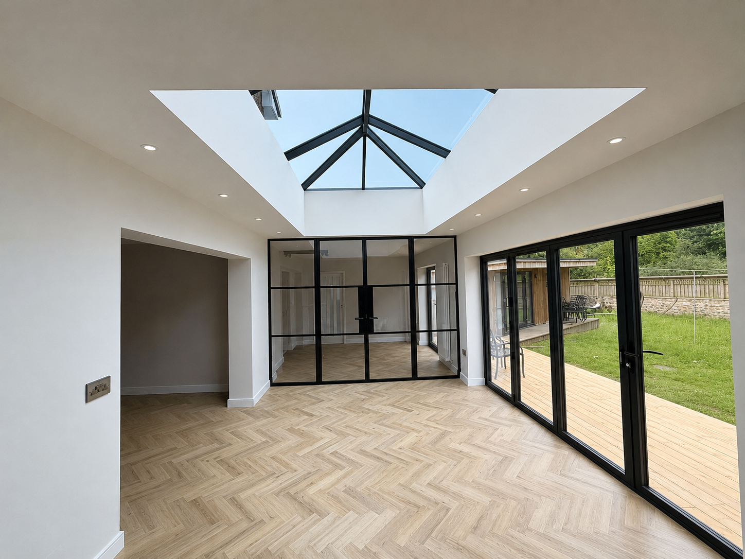 Bright orangery interior with herringbone flooring and garden views